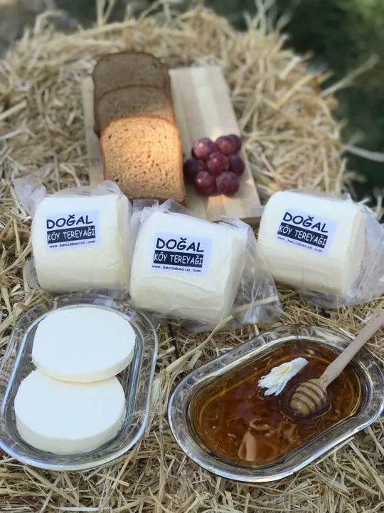 Saman üzerinde paketli doğal köy tereyağları, ekmek dilimleri ve bal